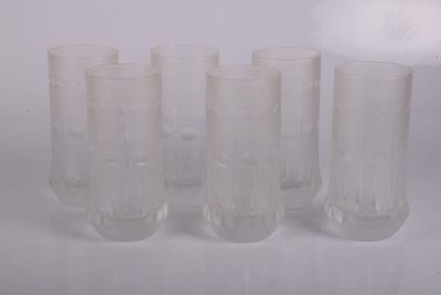 six verres transparents sont alignés sur une surface blanche