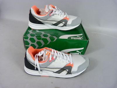 pair of white and orange sneakers sitting on top of a green box