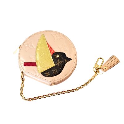a small purse with a bird on it and a chain