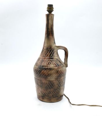 a brown vase that is sitting on a white surface