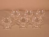 six empty wine glasses sitting on a table