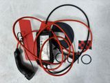 a red and black cord and a charger on a white surface