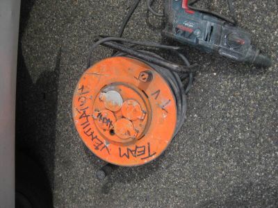 an orange object on the ground next to a corded cord