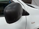 a small white car parked on the side of the street