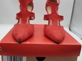 une paire de chaussures à talons hauts rouges posée sur une boîte