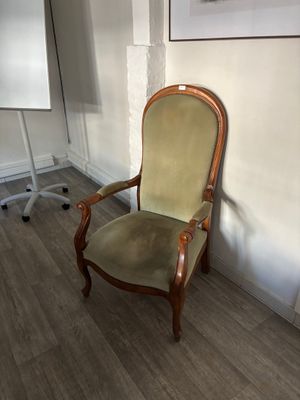 une chaise dans un coin d'une pièce où se trouve un tableau blanc accroché au mur