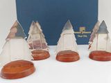 three small glass christmas trees are sitting in front of a blue box