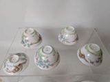six cups and saucers sitting on a glass table
