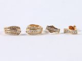 three pairs of gold and diamond rings on a white surface