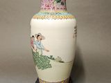 a vase with a painting on it sitting on a table