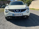 a white nissan juke parked in a parking lot