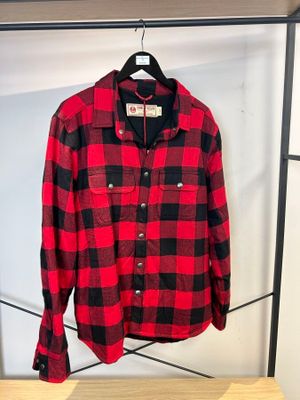 une chemise à carreaux rouges et noirs suspendue à un portant