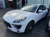 the white porsche macan is parked on the side of the street