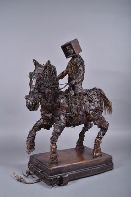 statue représentant un homme à cheval, portant une caisse sur le dos