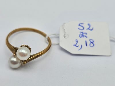 une image représentant une bague en or ornée de deux perles