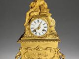 a gold clock with a statue on top of it
