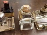 trois petites bouteilles en verre posées sur une table
