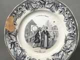 an old plate with a picture of a man and woman on it