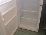 a white refrigerator with its door open on a tiled floor
