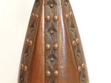 a brown vase sitting on a stand on a white surface