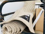 a stack of items on a chair with a fan in the background