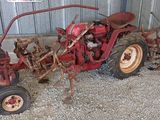 un tracteur rouge garé devant un bâtiment