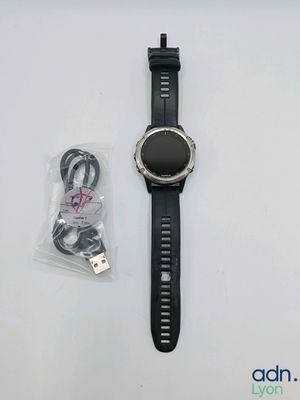 a smart watch sitting on a table next to a charger