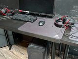 un bureau d'ordinateur équipé d'un écran, d'un clavier, de haut-parleurs et d'une souris