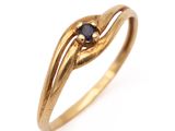 gros plan d'une bague en or avec un diamant noir