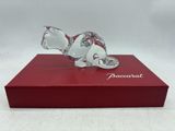 La figurine en verre représentant un chat est posée sur une boîte rouge.