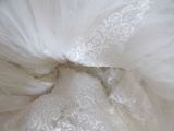 a close up of a wedding dress with a bow on it