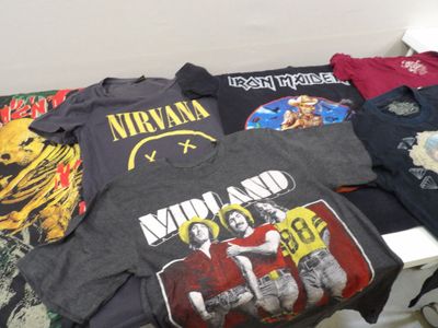 many t - shirts on a bed in a room