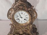 une horloge surmontée d'une statue, à côté d'une aiguille