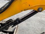 a close up of a yellow excavator that is parked in a parking lot