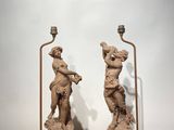 two statues of a man and a woman on marble bases