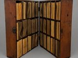 deux bibliothèques ouvertes en bois, remplies de livres, posées sur un plan de travail gris