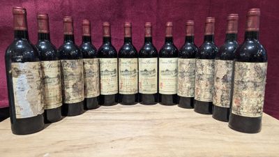 six bottles of wine are lined up on a wooden table