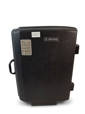 une valise noire posée sur une surface blanche