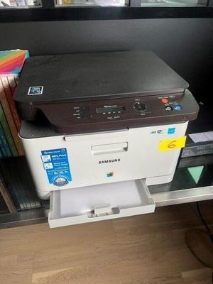 a printer that is sitting on top of a book shelf