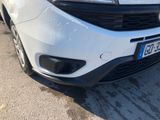 the front end of a white car parked on the side of the road