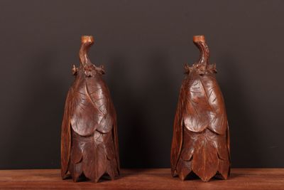 une paire de figurines d'oiseaux en bois sculpté posées sur une étagère en bois