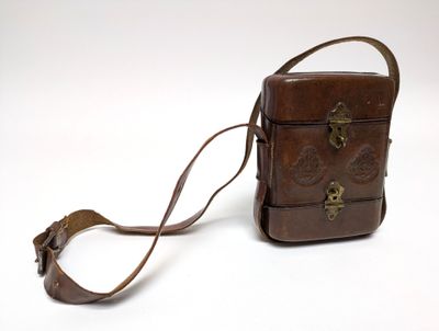 brown leather purse on white background with strap around it