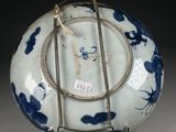 a blue and white vase on a metal stand