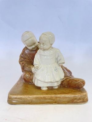 une figurine représentant un garçon et une fille assis sur un banc