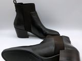 a pair of black leather ankle boots on a white background