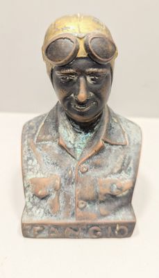 statue of a man with goggles on his head on a white surface