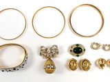 de nombreuses bagues et boucles d'oreilles posées sur une surface blanche