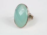 Gros plan sur une bague ornée d'une pierre verte