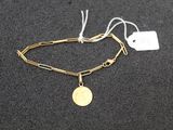 a gold chain bracelet with a coin on top of it