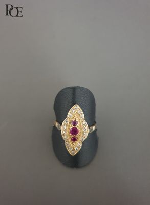 un gros plan d'une bague en or sertie d'un rubis au centre